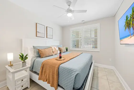 Primary Bedroom: A serene sanctuary featuring a King-sized bed, smart TV and a ceiling fan.