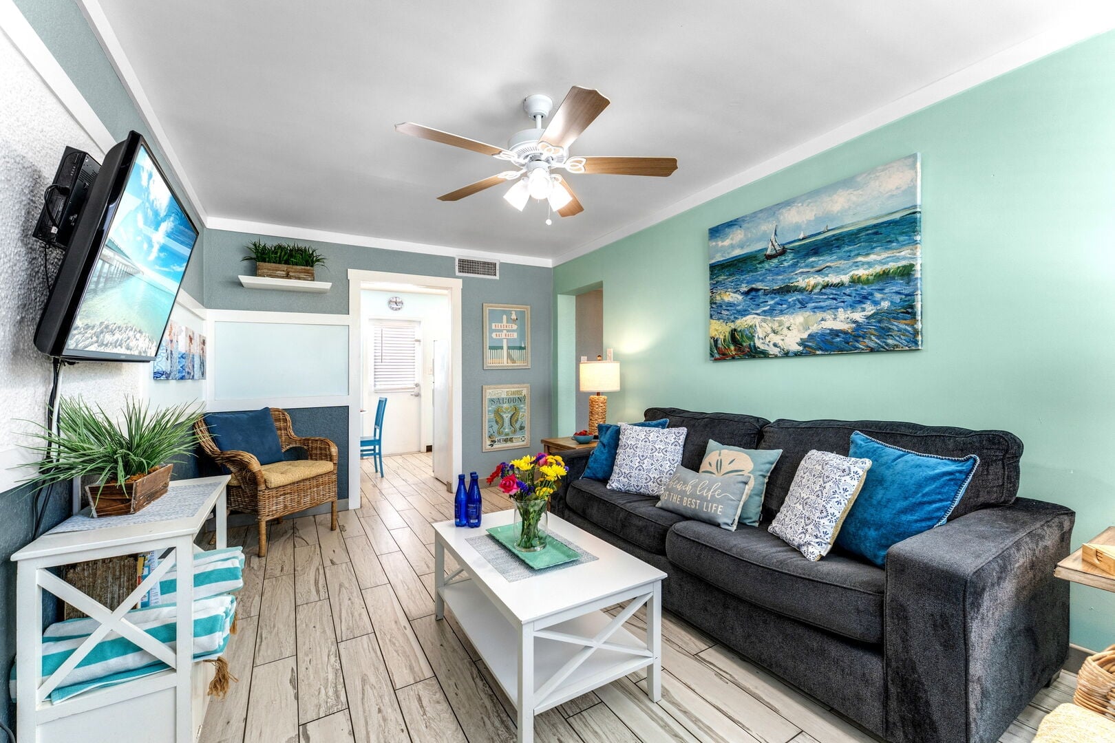 Clearwater Beach Suites 202: Living room area with a sofa bed, 2 single chairs, smart TV, and ceiling fan.