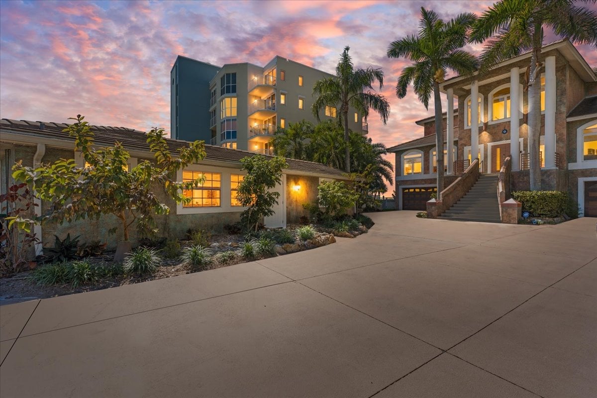 Coastal Dream: Spacious exterior with ample parking, surrounded by lush greenery and mature trees — a peaceful coastal retreat from the moment you arrive.