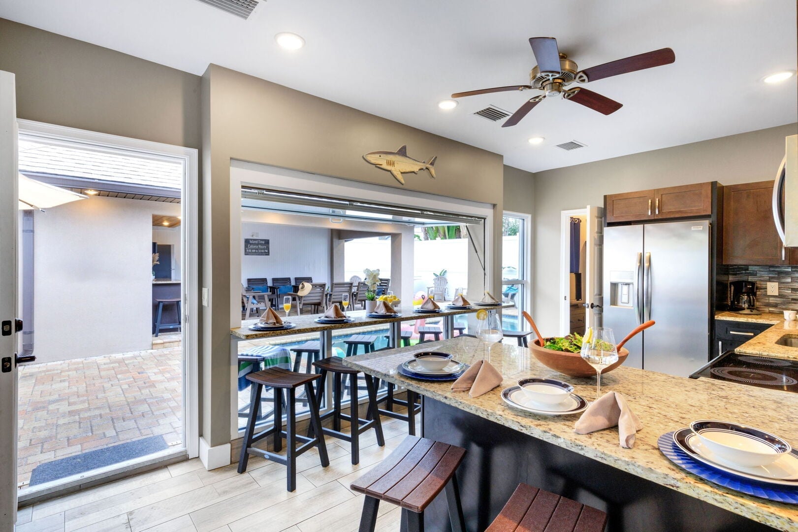 Island Time: Indoor/Outdoor Bar – A unique kitchen pass-through window with seating for 10—perfect for serving drinks and snacks poolside.