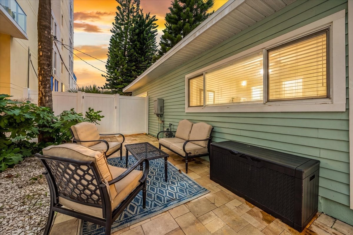 Sandy Shores 2: Step outside to a furnished patio with comfortable seating, a coffee table, and a coastal-inspired rug for relaxing in the fresh Florida air.