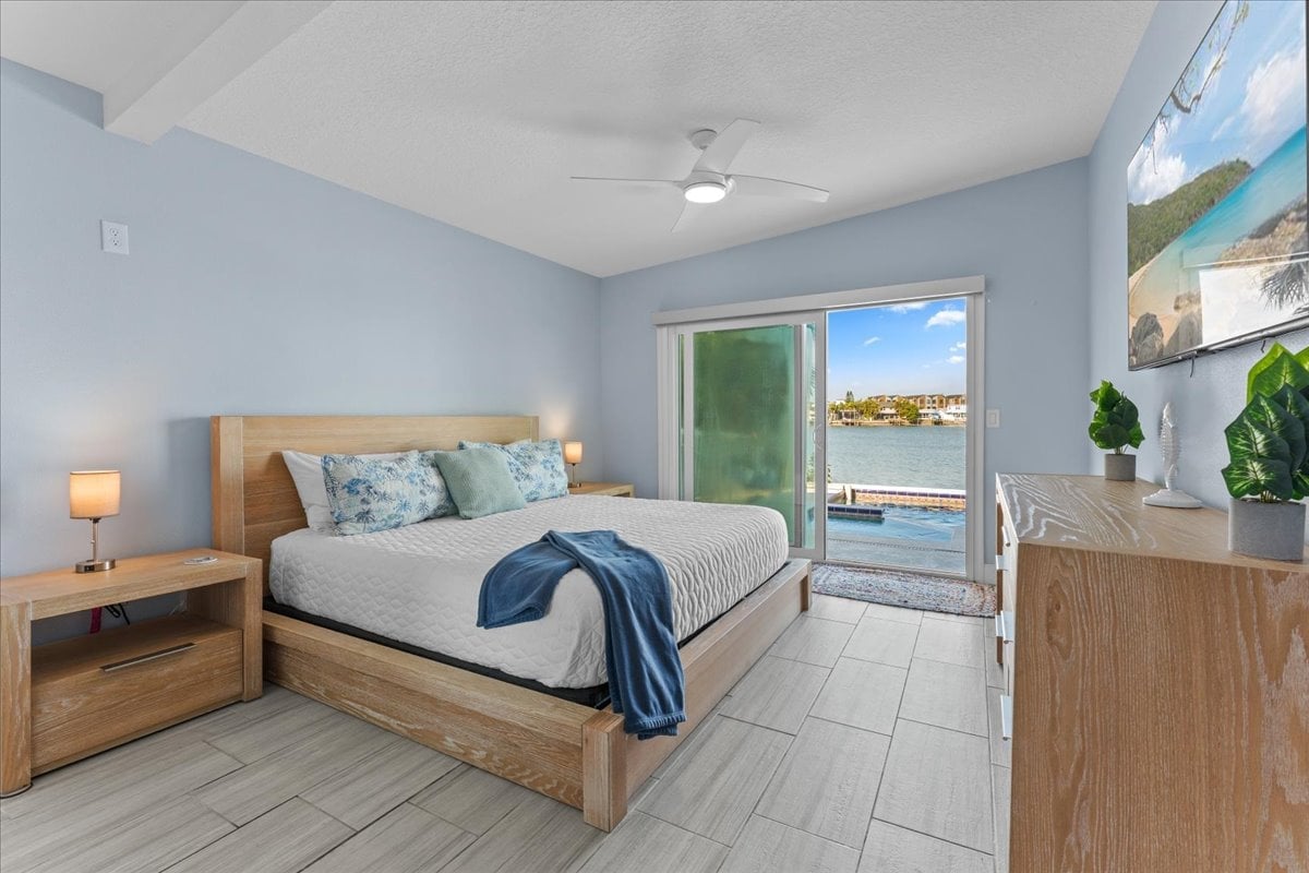 Water Lover's Paradise: Enjoy direct access to the waterfront pool deck from our master bedroom. This room has a king sized bed, smart tv, ceiling fan and ensuite bathroom.