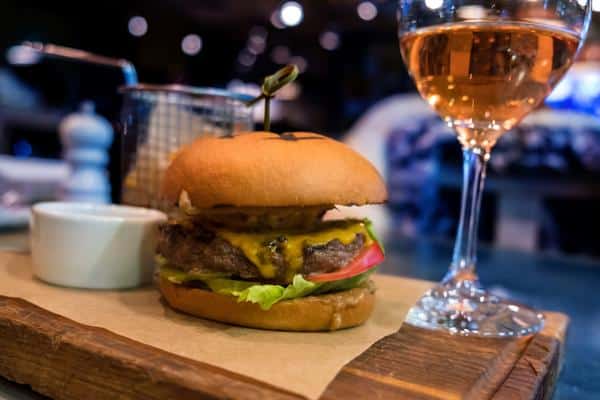 dinner with burger and glass of wine in a bar