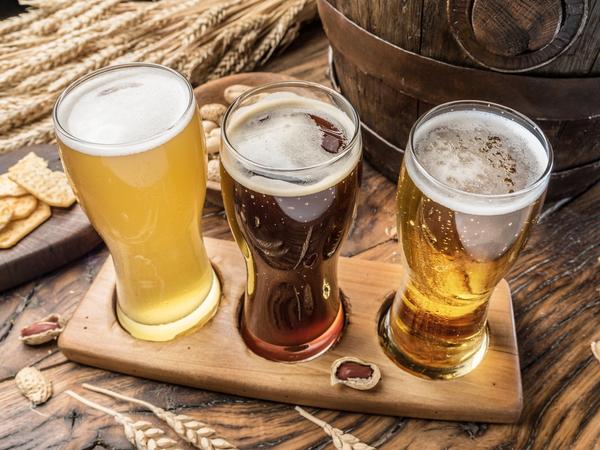 three craft beers on wooden beer flight board