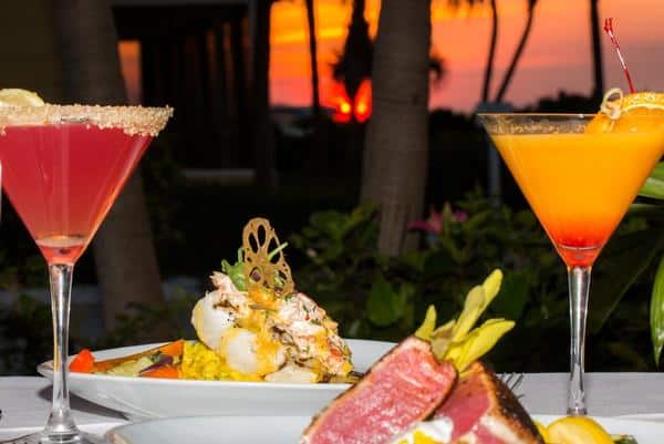 outdoor dinner of tuna steak, grouper and martinis at a table at sunset