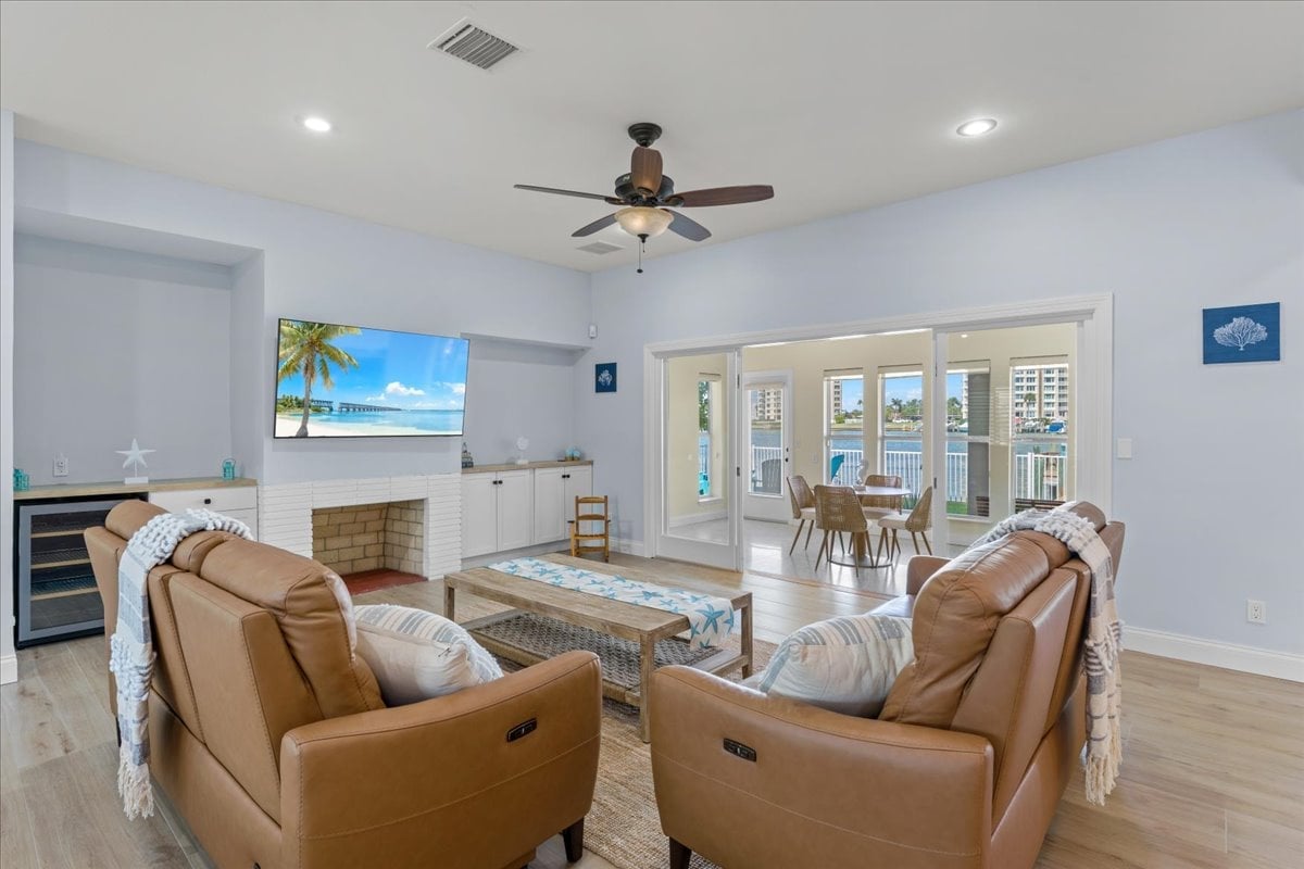 The bright and airy living room offers the perfect place to unwind after a day at the beach, complete with comfortable seating and serene waterfront scenery right outside the windows.