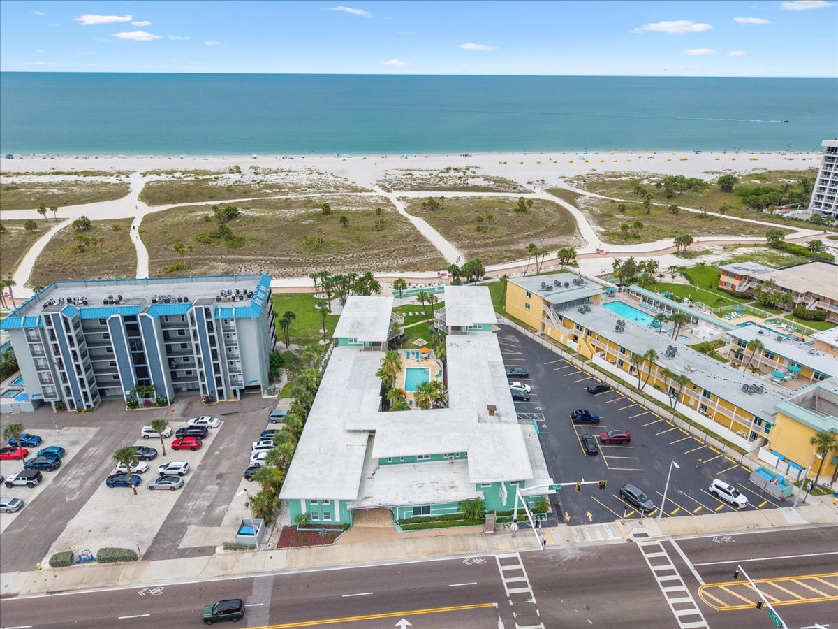 Aerial view of Tropic Terrace — just steps from the sand on Treasure Island's Beach Boardwalk, with the Gulf, on-site parking, and lush palms all in view.